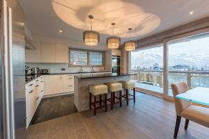 a kitchen with a large island with bar stools at Apartment La Forêt 2 - Spa access in Nendaz