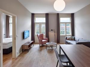 salon z łóżkiem, kanapą i stołem w obiekcie Franz BY ZEITRAUM w Pradze