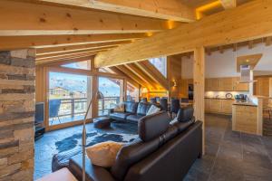 uma sala de estar com mobiliário de couro e uma grande janela em Montagnard 12 - spa access - car and careless holidays! em Nendaz