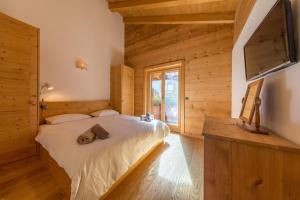 a bedroom in a log cabin with a bed and a television at Montagnard 12 - spa access - car and careless holidays! in Nendaz