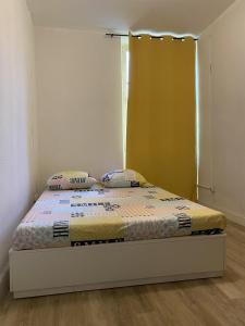 een bed met twee kussens in een kamer bij L’Éphémère La Canebière in Marseille
