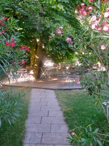 Una pasarela con bancos y flores en un parque en Gasthaus Sonne Khaled Al Homsi, en Vörstetten