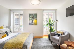 a bedroom with a bed and a couch and a chair at São Miguel Apartments in Porto
