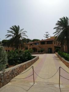 un edificio con palme di fronte a un vialetto di Villa Oasi Dei Sogni a Lampedusa