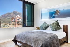 ein Schlafzimmer mit einem Bett und einem großen Fenster in der Unterkunft Always-Power Luxury Sky Retreat in Kapstadt