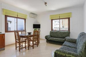 - un salon avec une table, des chaises et un canapé dans l'établissement Casa Valeria, à Conil de la Frontera