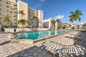 a swimming pool with lounge chairs and a building at Beachfront Siesta Key Condo with Pool Access! in Siesta Key