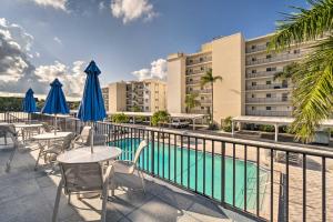 a hotel patio with tables and umbrellas and a pool at Beachfront Siesta Key Condo with Pool Access! in Siesta Key