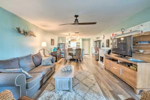 a living room with a couch and a tv at Beachfront Siesta Key Condo with Pool Access! in Siesta Key