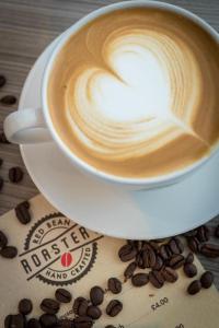 a cup of coffee sitting on a table with coffee beans at Maldron Hotel Manchester City Centre in Manchester