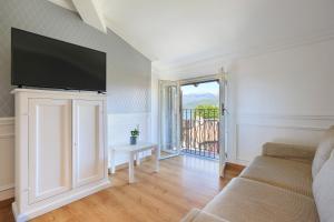 ein Wohnzimmer mit Sofa und Flachbildfernseher in der Unterkunft Pandora Stresa - By Impero House in Stresa