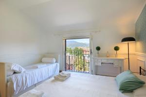 a room with a bed and a desk and a window at Pandora Stresa - By Impero House in Stresa