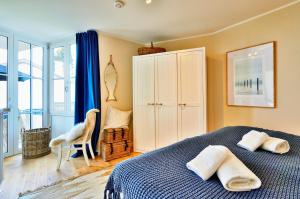 a bedroom with a bed with two towels on it at Ferienwohnung Hafenliebe, Villa Vilmblick mit Meerblick in Lauterbach