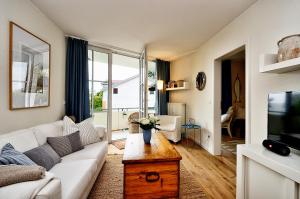 a living room with a couch and a tv at Ferienwohnung Hafenliebe, Villa Vilmblick mit Meerblick in Lauterbach