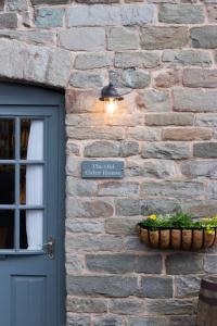 ceglany budynek z drzwiami i napisem w obiekcie The Old Cider House w mieście Hay-on-Wye