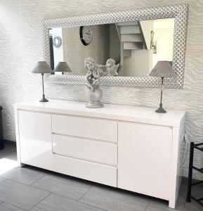 eine weiße Kommode mit zwei Lampen und einem Spiegel in der Unterkunft Villa la Vie, Maison entière pour 4 personnes, avec extérieur, Tout inclus, ménage, linge, wifi in Dieppe + 15 Fotos