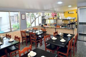 a restaurant with tables and chairs and a kitchen at Hotel Rio Claro in Rio de Janeiro