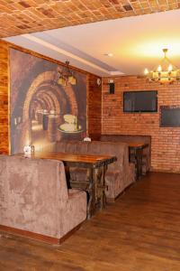 a movie room with couches and a wall with a mural at Хутор-city in Korostyshiv