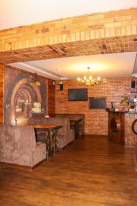 a room with couches and tables and a brick wall at Хутор-city in Korostyshiv