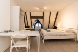 1 dormitorio con cama, escritorio, cama y mesa en RedLight District Smokers Friendly Private Studio en Ámsterdam