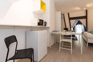 a small kitchen and living room with a refrigerator and a table at RedLight District Smokers Friendly Private Studio in Amsterdam