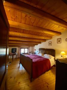 een slaapkamer met een groot bed en houten plafonds bij B&B Altè in Paderno del Grappa