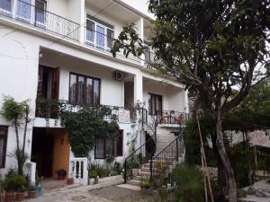 a white house with stairs and a tree at Guest House Buche on Agmashenebeli 219 in K'obulet'i