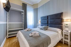 een slaapkamer met een groot bed en handdoeken bij Rione XXII Apartments in Rome