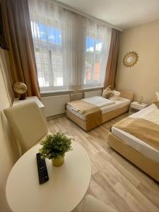 ein Hotelzimmer mit 2 Betten, einem Tisch und einem sidx sidx in der Unterkunft Altstadt-Hotel Gosequell in Goslar