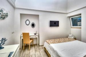 una camera d'albergo con letto e scrivania di Casa di Joe a Capri