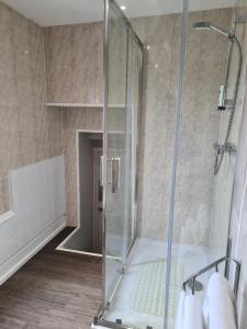 a shower with a glass door in a bathroom at The Royal Albion in Walton-on-the-Naze