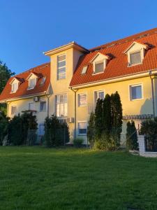 una casa con techo rojo y patio verde en Németh Apartman Sárvár, en Sárvár