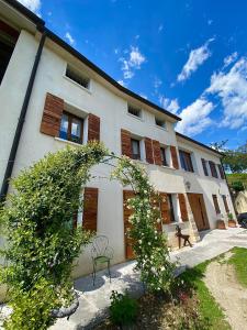 a large white building with wooden shuttered windows at B&B Altè in Paderno del Grappa