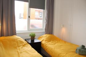 a bedroom with a yellow bed and a window at Hengelo-Inn in Hengelo