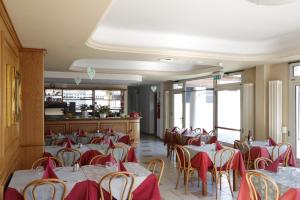 a restaurant with tables and chairs with red napkins at Hotel Cavaria in San Fedele Intelvi