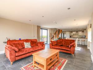 a living room with two orange couches and a table at Old Willow Barn in Boston