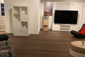 a living room with a flat screen tv on a white wall at Comfortable chalet close to ski slopes in Grindelwald