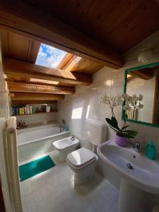 een badkamer met een toilet, een wastafel en een bad bij B&B Altè in Paderno del Grappa