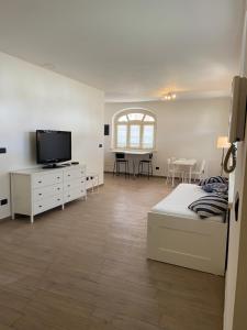 een slaapkamer met een bed en een televisie en een tafel bij Coronata 22 in Fossano