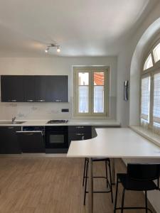 uma grande cozinha com uma mesa branca e cadeiras em Coronata 22 em Fossano
