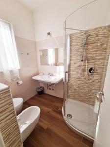uma casa de banho com um chuveiro, um WC e um lavatório. em Hotel Camelia em Rimini