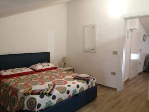 a bedroom with a bed with a colorful blanket at B&B I GEMELLI in Sorbolo