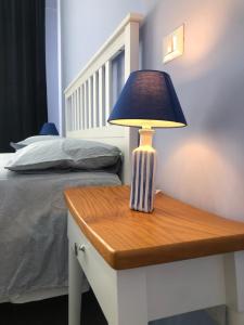 ナポリにあるMelisurgo Propertyのベッド横のテーブルの上のランプ