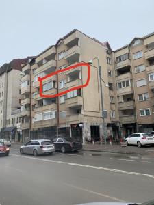 un grand immeuble avec un cercle rouge. dans l'établissement Lovely Hotel & Apartment for rent in center of Gjilan, à Gnjilane