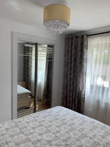 a bedroom with a bed and a chandelier at Apartament Micsunelelor in Iaşi