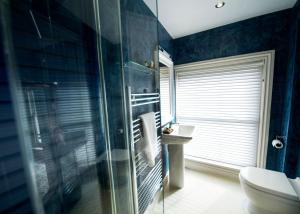 a bathroom with a glass shower and a toilet at East Walls Hotel in Chichester