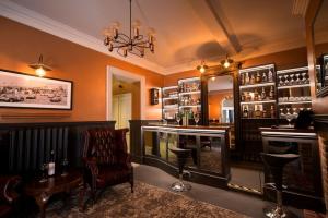 a bar with a chair and a chandelier at East Walls Hotel in Chichester