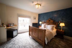 a bedroom with a large bed with a blue wall at East Walls Hotel in Chichester