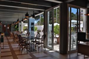 un comedor con mesas, sillas y ventanas en Hotel Jerez & Spa, en Jerez de la Frontera