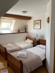 - 2 lits jumeaux dans une chambre avec fenêtre dans l'établissement The Gingerbread House Cottage, à Beauficel
